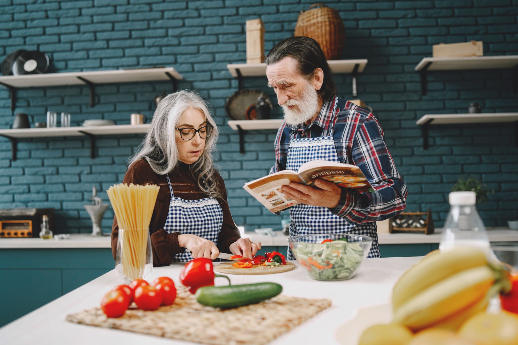 An older couple preparing fresh food together in a kitchen